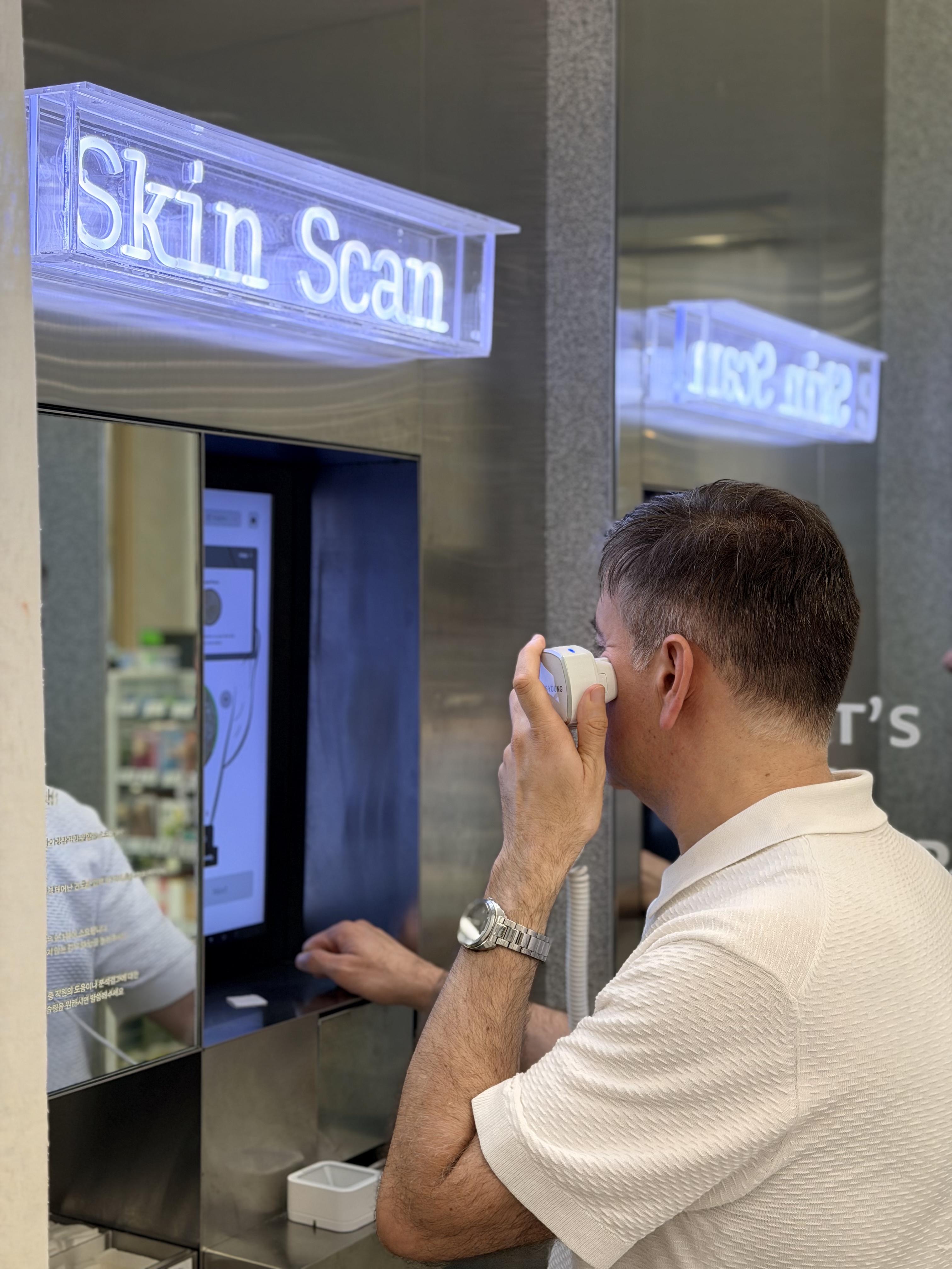 Customer using a handheld camera device for facial skin capture